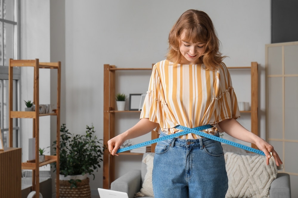 Woman measuring her waist after body contouring