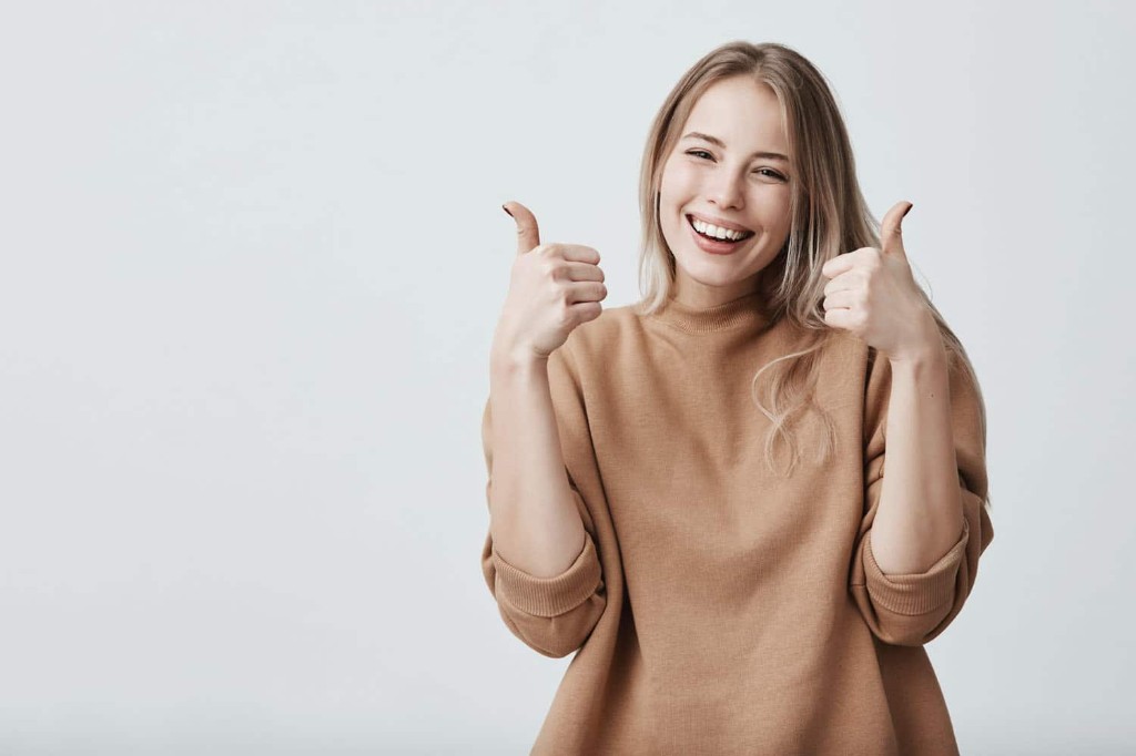 Smiling patient giving two thumbs up